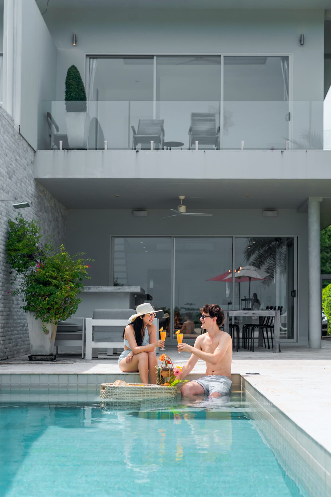 A couple enjoying a floating breakfast in their private villa pool