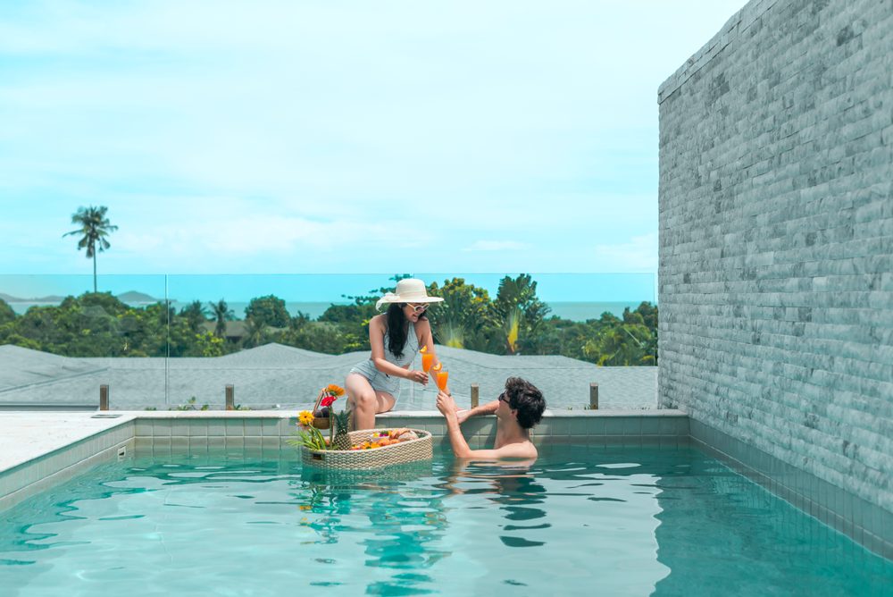 A couple raising a toast at a floating breakfast with sea views