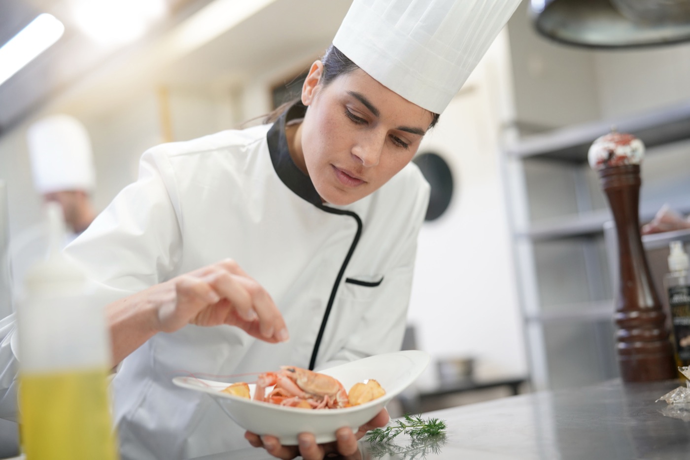 A chef carefully plating a seafood dish